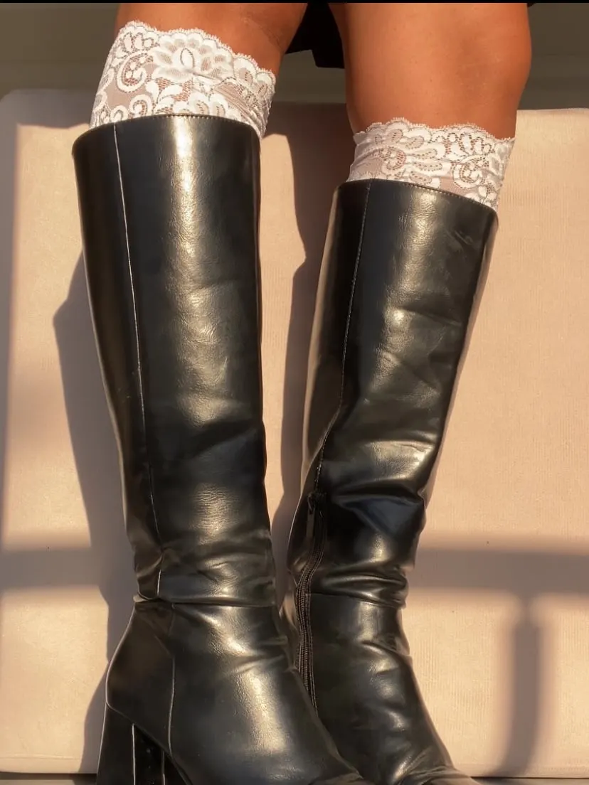 White lace bands worn above black knee-high boots